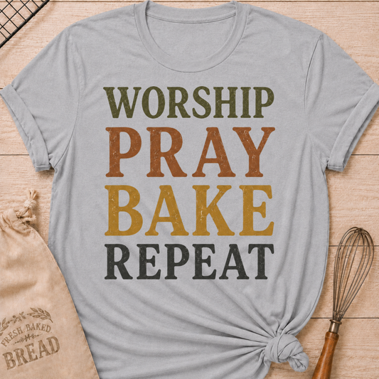 Athletic Heather Worship Pray Bake Repeat women's relaxed fit tee with bold stacked vintage typography in warm retro colors