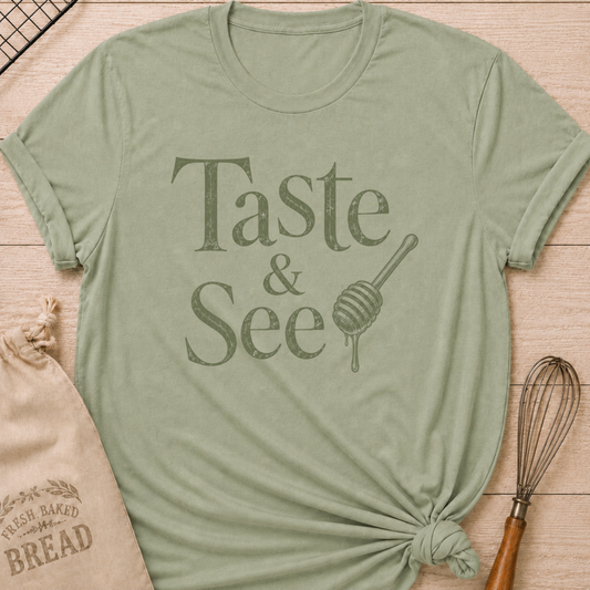 Sage green women's relaxed fit t-shirt with the words Taste and See in vintage lettering and a dripping honey dipper.