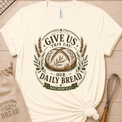 Natural cream women's relaxed fit t-shirt with the Daily Bread emblem, a clean badge-style bread illustration inspired by Matthew 6:11.