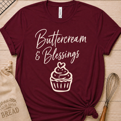 Maroon women's relaxed fit t-shirt with Buttercream and Blessings in flowing script above a cupcake topped with a heart.
