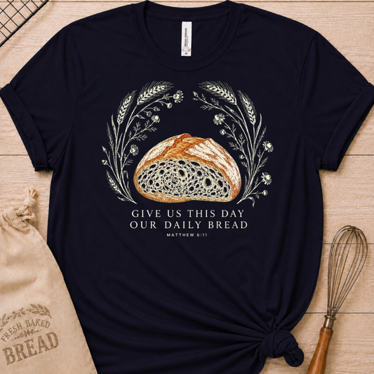 Navy women's relaxed fit t-shirt with the Daily Bread design featuring a rustic loaf of bread wreathed in wheat and flowers, inspired by Matthew 6:11.