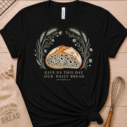 Black women's relaxed fit t-shirt with the Daily Bread design featuring a rustic loaf of bread wreathed in wheat and flowers, inspired by Matthew 6:11.
