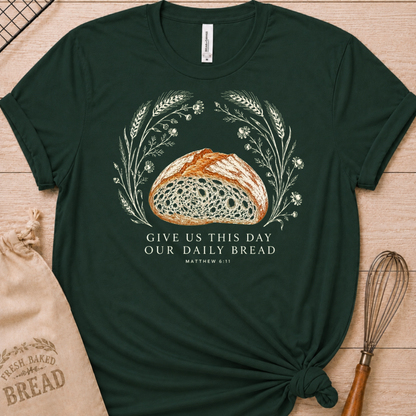 Forest green women's relaxed fit t-shirt with the Daily Bread design featuring a rustic loaf of bread wreathed in wheat and flowers, inspired by Matthew 6:11.