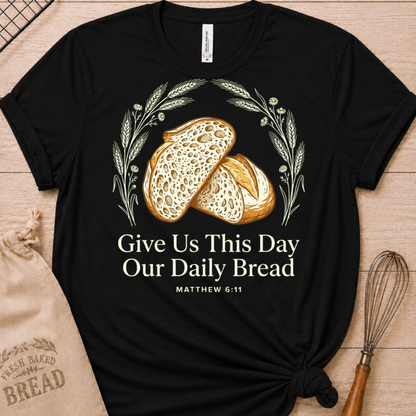 Black women's relaxed fit t-shirt with the Daily Bread design featuring two rustic half loaves side by side, inspired by Matthew 6:11.