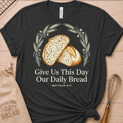 Dark heather grey women's relaxed fit t-shirt with the Daily Bread design featuring two rustic half loaves side by side, inspired by Matthew 6:11.