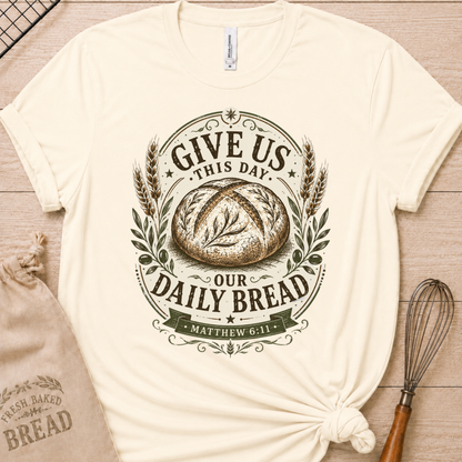 Natural cream women's relaxed fit t-shirt with the Daily Bread emblem printed in cream, a clean badge-style bread illustration inspired by Matthew 6:11.