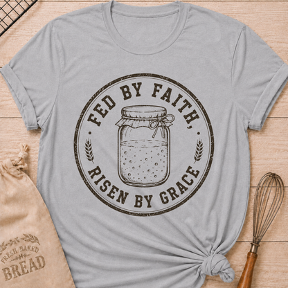 Athletic heather women's relaxed fit t-shirt with a vintage sourdough starter jar, wheat and the words Fed by Faith, Risen by Grace.