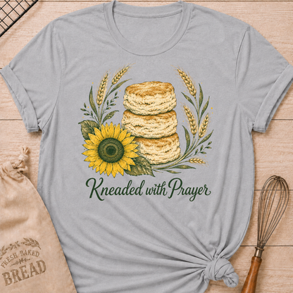 Athletic Heather Kneaded With Prayer women's relaxed fit tee with a stack of homemade biscuits, golden wheat, and a sunflower