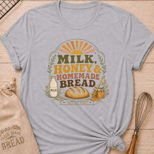 Athletic heather women's relaxed fit t-shirt with the words Milk, Honey & Homemade Bread in vintage lettering with a rustic loaf, an old-fashioned milk bottle, and a jar of honey beneath a retro sunrise.
