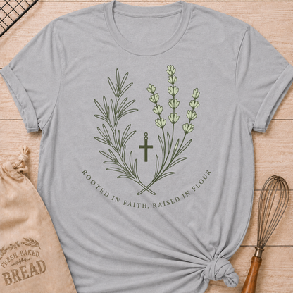 Athletic heather women's relaxed fit t-shirt with rosemary, lavender and a simple cross and the words Rooted in Faith, Raised in Flour.