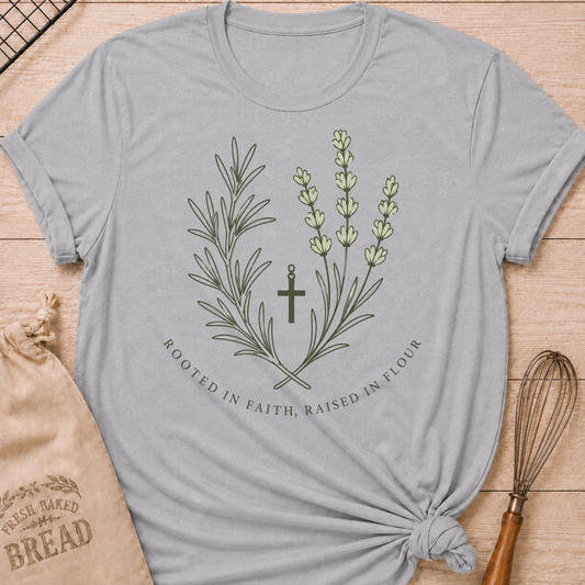 Athletic heather women's relaxed fit t-shirt with rosemary, lavender and a simple cross and the words Rooted in Faith, Raised in Flour.