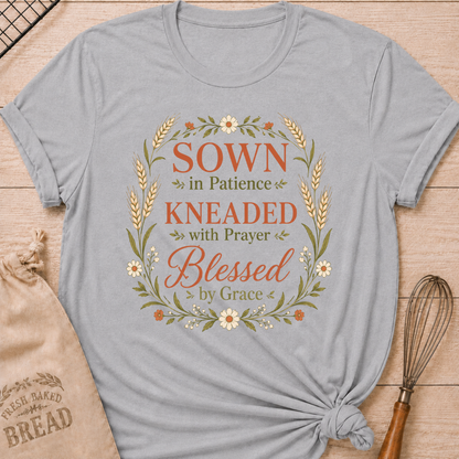Athletic heather women's relaxed fit t-shirt with the words Sown in Patience, Kneaded with Prayer, Blessed by Grace framed in wheat, daisies and delicate greenery.