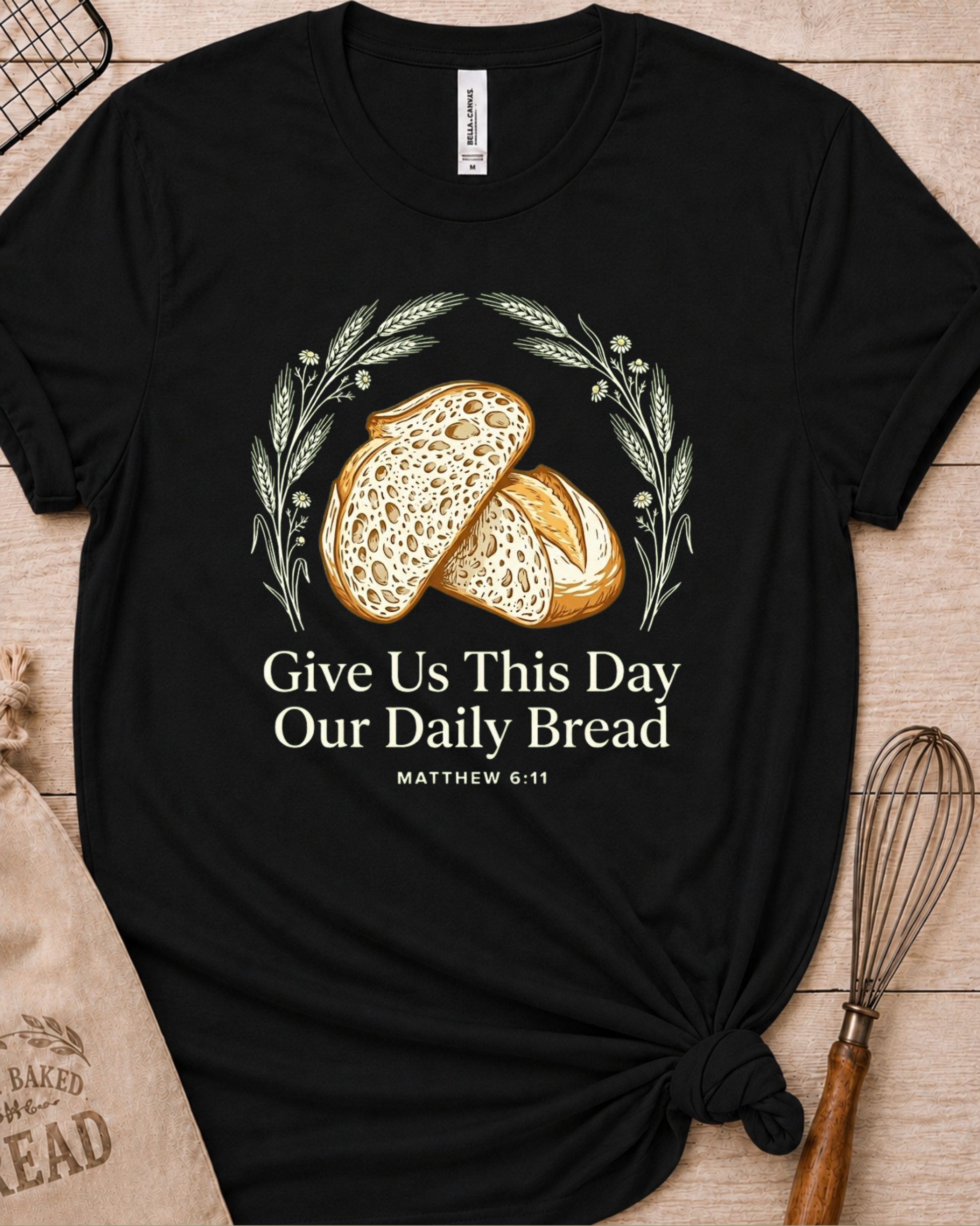 Black women's relaxed fit t-shirt with the Daily Bread design featuring two rustic half loaves side by side, inspired by Matthew 6:11.