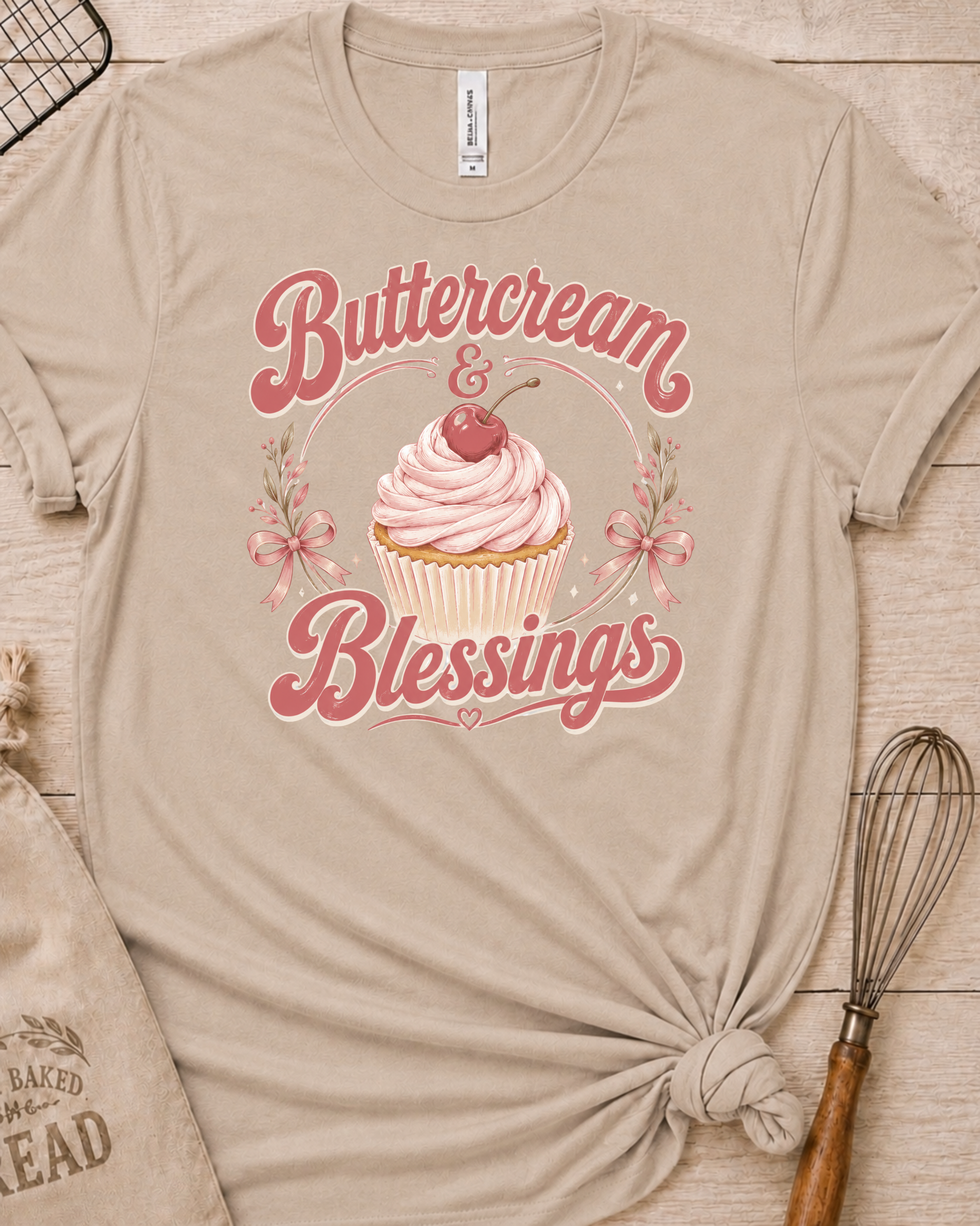 Heather stone women's relaxed fit t-shirt reading Buttercream and Blessings with a frosted cupcake and a delicate bow.