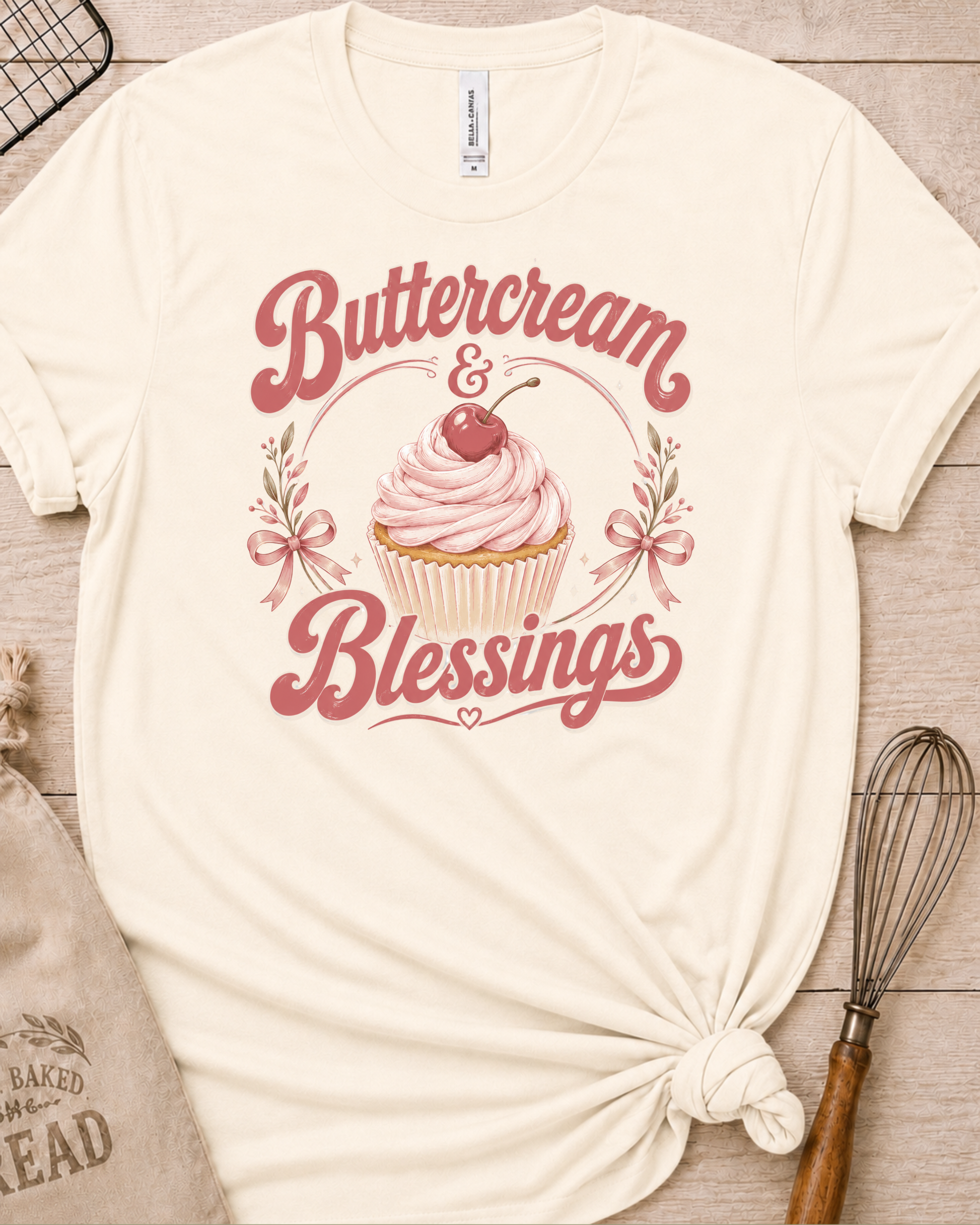 Natural cream women's relaxed fit t-shirt reading Buttercream and Blessings with a frosted cupcake and a delicate bow.