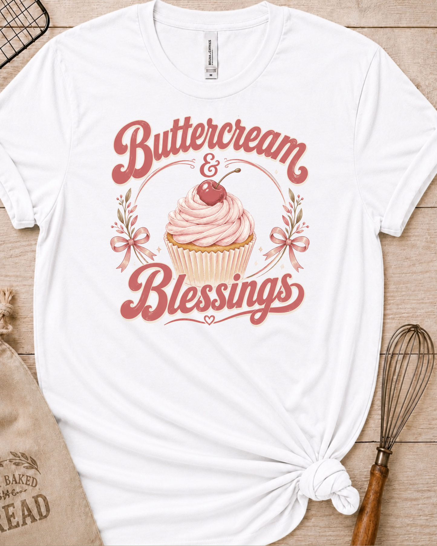 White women's relaxed fit t-shirt reading Buttercream and Blessings with a frosted cupcake and a delicate bow.