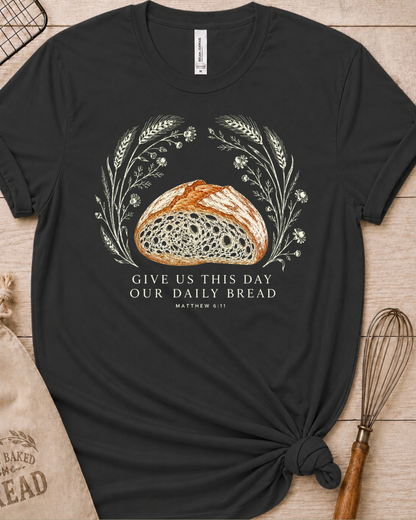Dark heather grey women's relaxed fit t-shirt with the Daily Bread design featuring a rustic half loaf of bread, inspired by Matthew 6:11.