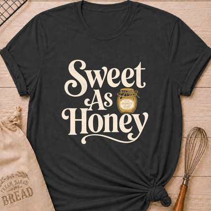 Dark heather grey women's relaxed fit t-shirt with the words Sweet as Honey in playful vintage lettering and a jar of golden honey.