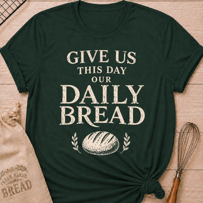 Forest green women's relaxed fit t-shirt with the words Give Us This Day Our Daily Bread in bold vintage lettering above a rustic loaf and leafy accents.