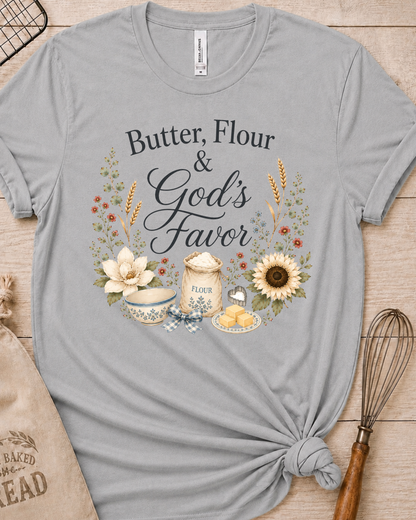 Heather grey women's relaxed fit t-shirt reading Butter, Flour and God's Favor, framed by a flour sack, a mixing bowl, butter, a sunflower, and wildflowers.