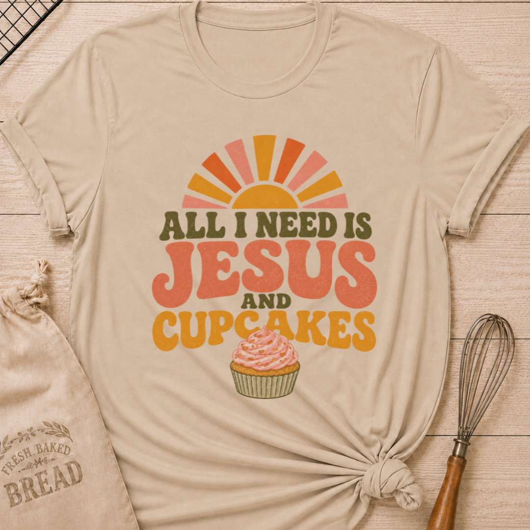 Heather Stone All I Need Is Jesus and Cupcakes women's relaxed fit tee with retro lettering and a pink frosted cupcake in warm sunrise colors