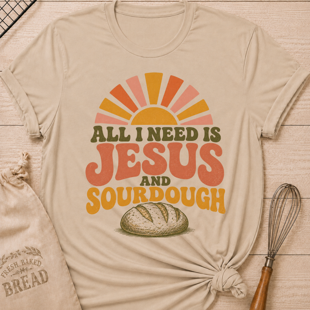Heather Stone All I Need Is Jesus and Sourdough women's relaxed fit tee with bold retro lettering, a rustic artisan loaf, and a sunrise