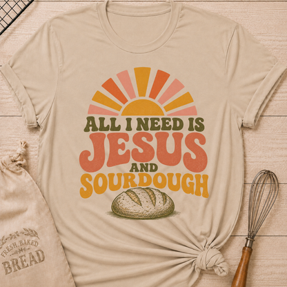 Heather Stone All I Need Is Jesus and Sourdough women's relaxed fit tee with bold retro lettering, a rustic artisan loaf, and a sunrise