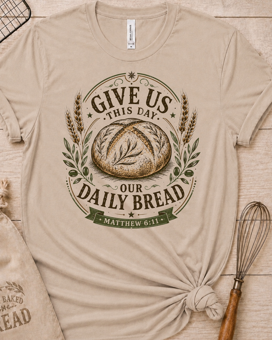 Heather stone women's relaxed fit t-shirt with the Daily Bread emblem, a clean badge-style bread illustration inspired by Matthew 6:11.