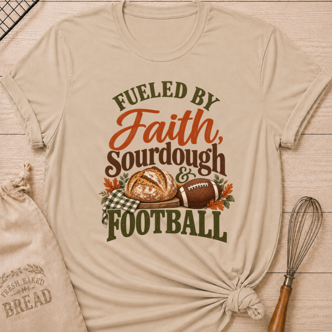 Heather Stone women's relaxed fit tee with bold vintage Fueled by Faith Sourdough and Football lettering, a rustic sourdough loaf, classic football, gingham accents and autumn leaves