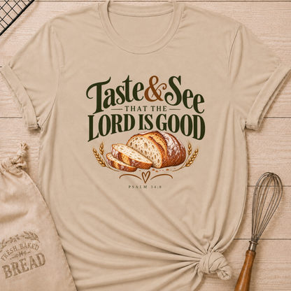 Heather Stone women's relaxed fit tee with bold vintage Taste and See That the Lord Is Good lettering above a sliced artisan loaf, golden wheat, and Psalm 34:8