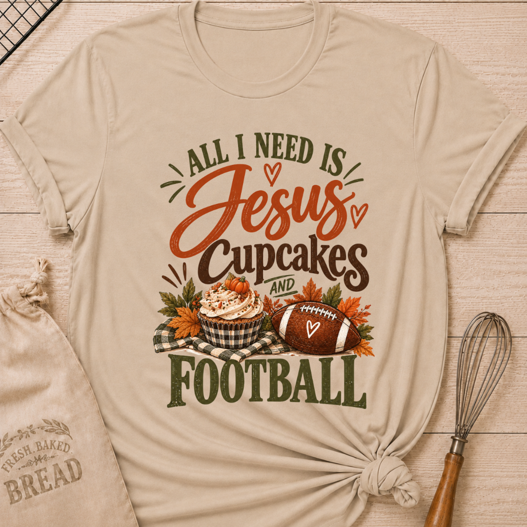 Heather Stone women's relaxed fit tee with bold vintage All I Need Is Jesus, Cupcakes and Football lettering, a pumpkin topped cupcake, autumn leaves and a football on a gingham blanket