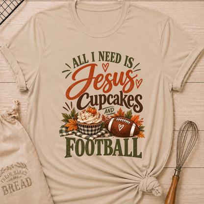 Heather Stone women's relaxed fit tee with bold vintage All I Need Is Jesus, Cupcakes and Football lettering, a pumpkin topped cupcake, autumn leaves and a football on a gingham blanket