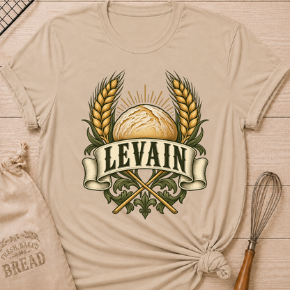 Heather Stone women's relaxed fit tee with a rustic loaf between golden wheat and radiant accents, with Levain lettering on an old-world banner