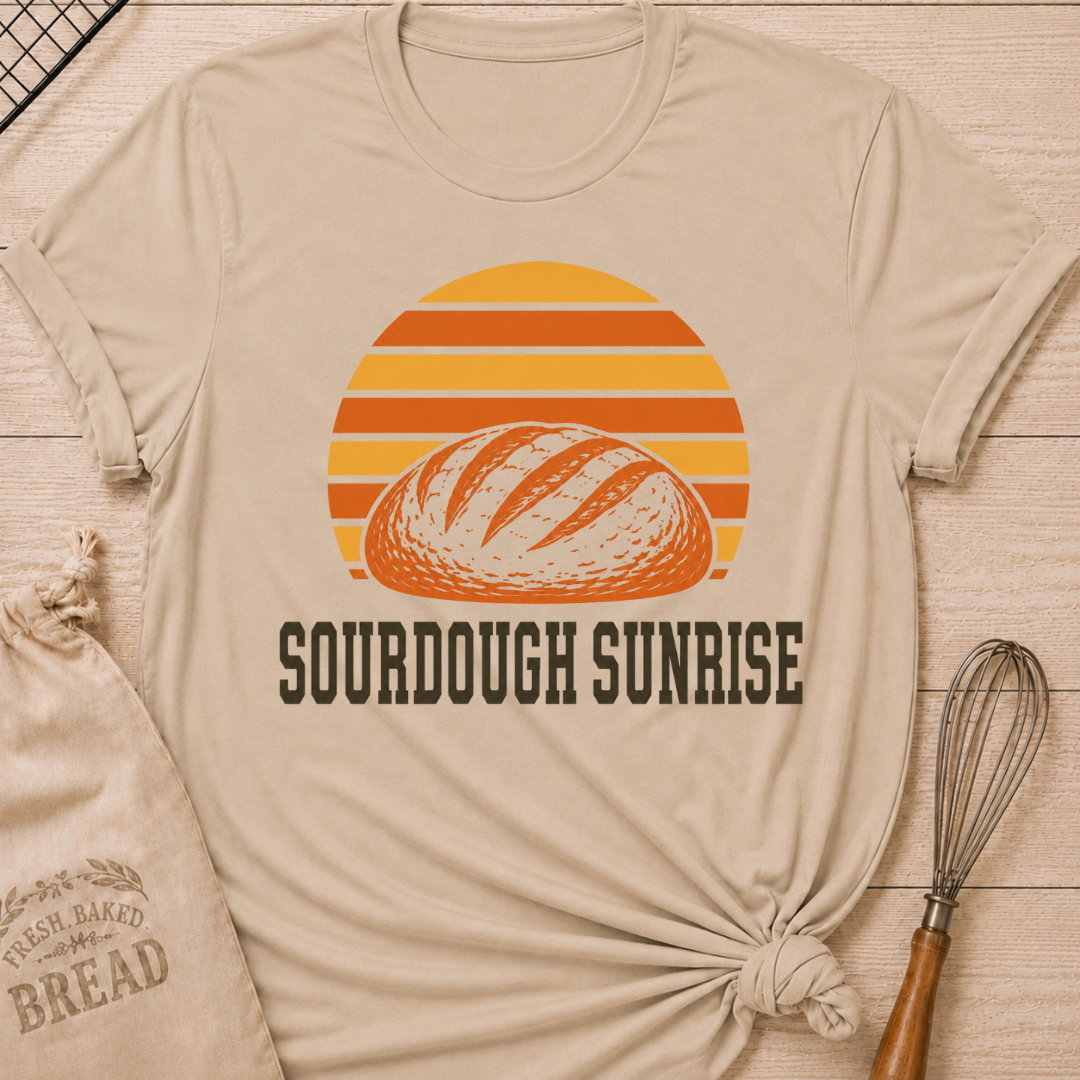 Heather stone women's relaxed fit t-shirt with a hand-scored sourdough loaf and a bold retro sunrise in rich harvest colors.
