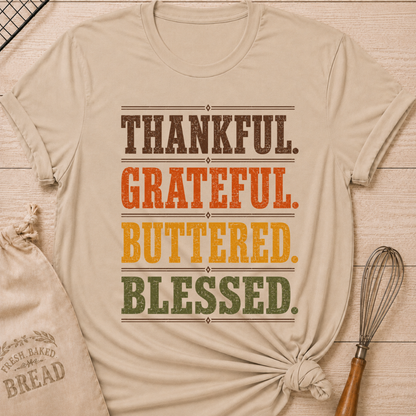 Heather Stone women's relaxed fit tee with bold distressed Thankful Grateful Buttered Blessed lettering stacked in warm harvest brown, orange, gold and olive