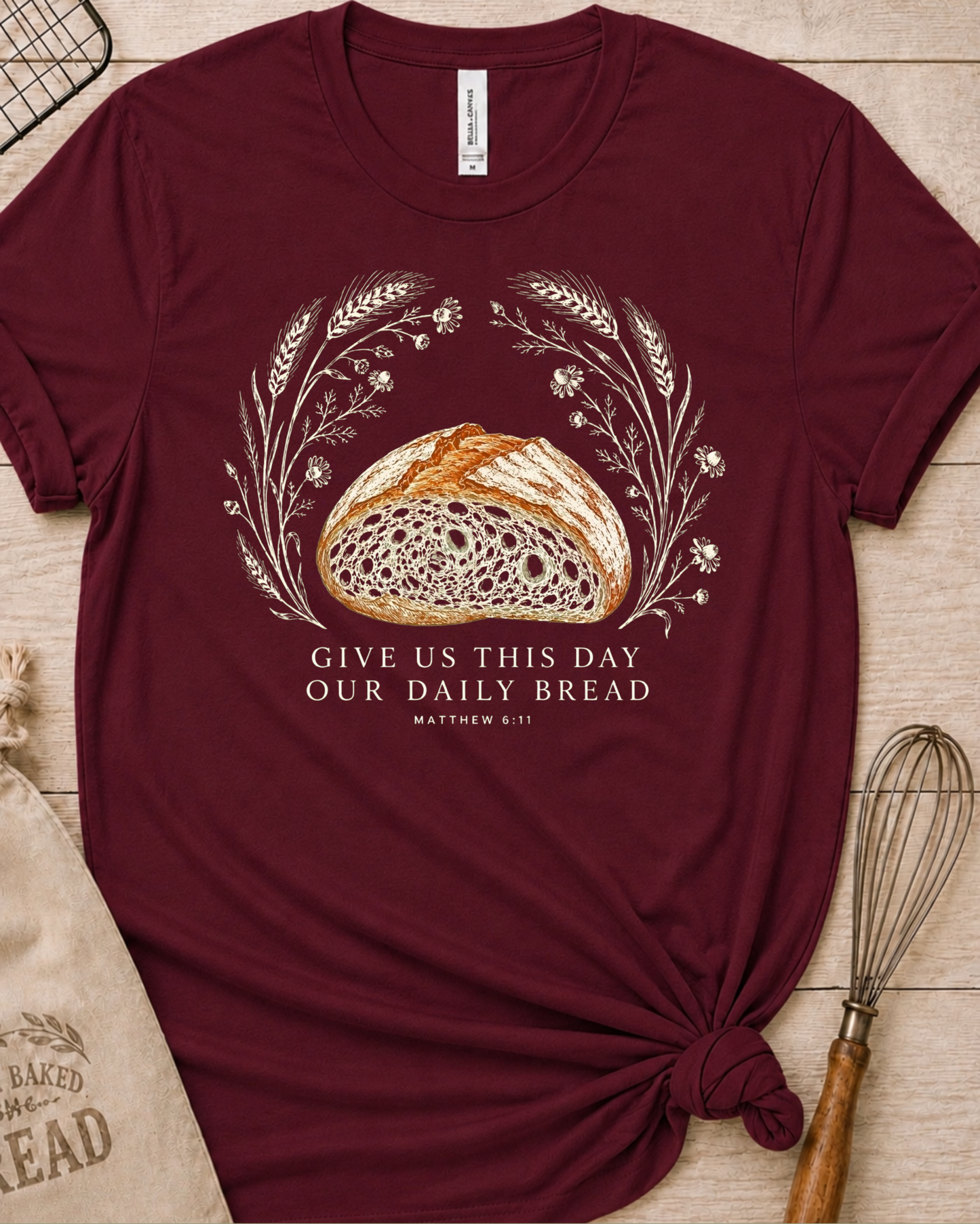 Maroon women's relaxed fit t-shirt with the Daily Bread design featuring a rustic half loaf of bread, inspired by Matthew 6:11.