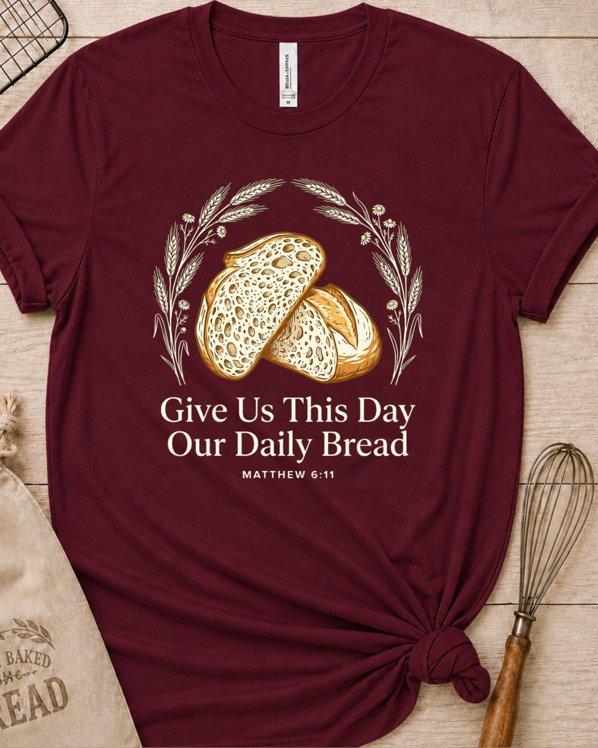 Maroon women's relaxed fit t-shirt with the Daily Bread design featuring two rustic half loaves side by side, inspired by Matthew 6:11.