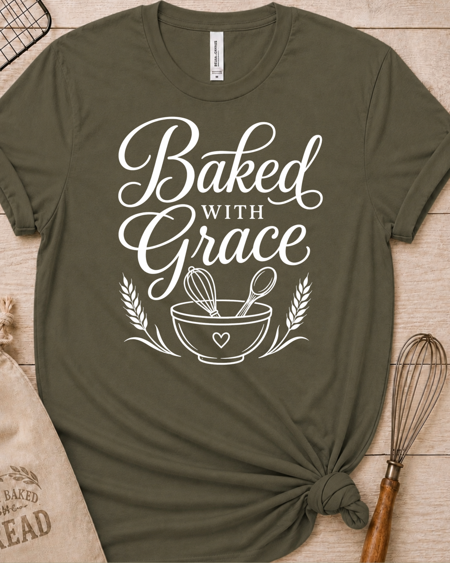 Military green women's relaxed fit t-shirt with Baked with Grace in white script above a mixing bowl with a whisk and wooden spoon.