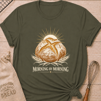 Military Green women's relaxed fit tee with a rustic artisan loaf rising beneath a radiant sun, framed by golden wheat in a warm vintage style, above Morning by Morning lettering