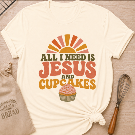 Natural All I Need Is Jesus and Cupcakes women's relaxed fit tee with retro lettering and a pink frosted cupcake in warm sunrise colors
