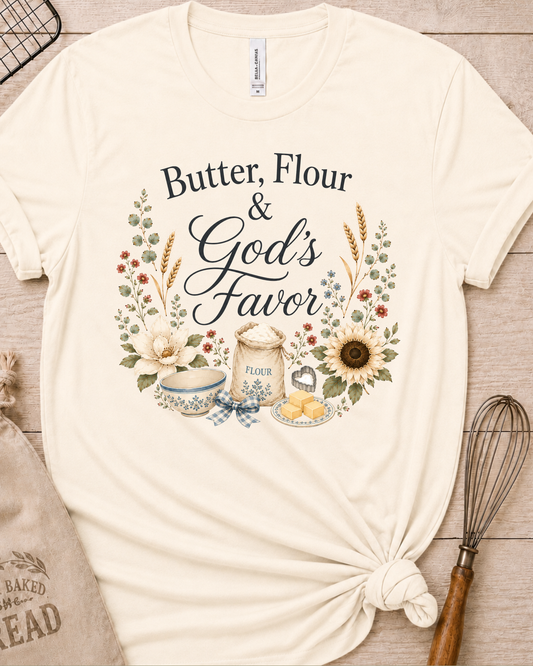 Natural cream women's relaxed fit t-shirt reading Butter, Flour and God's Favor, framed by a flour sack, a mixing bowl, butter, a sunflower, and wildflowers.