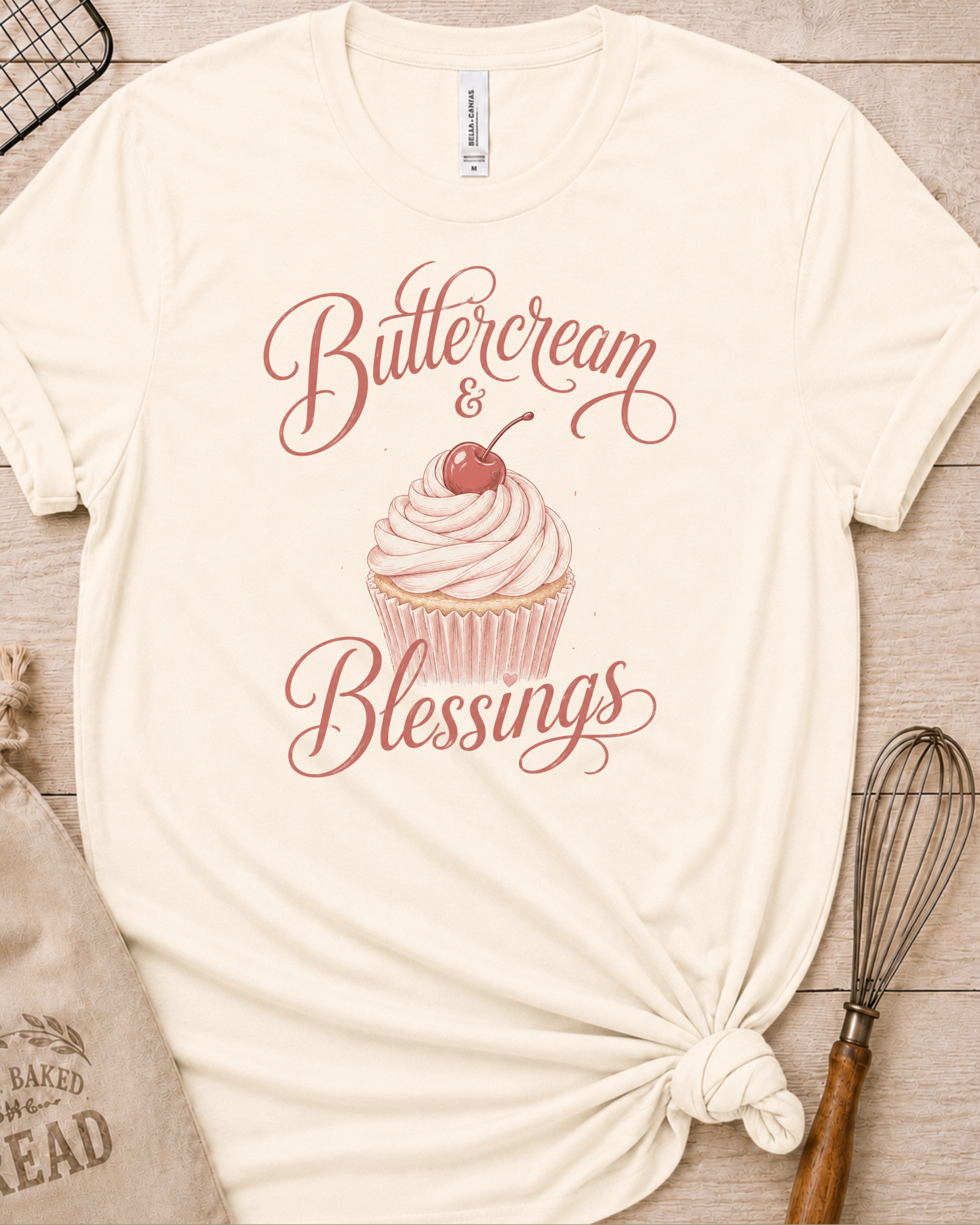 Natural cream women's relaxed fit t-shirt reading Buttercream and Blessings with a frosted cupcake illustration.