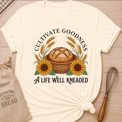 Natural Cultivate Goodness, A Life Well Kneaded women's relaxed fit tee with a rustic bread basket, golden wheat, and cheerful sunflowers