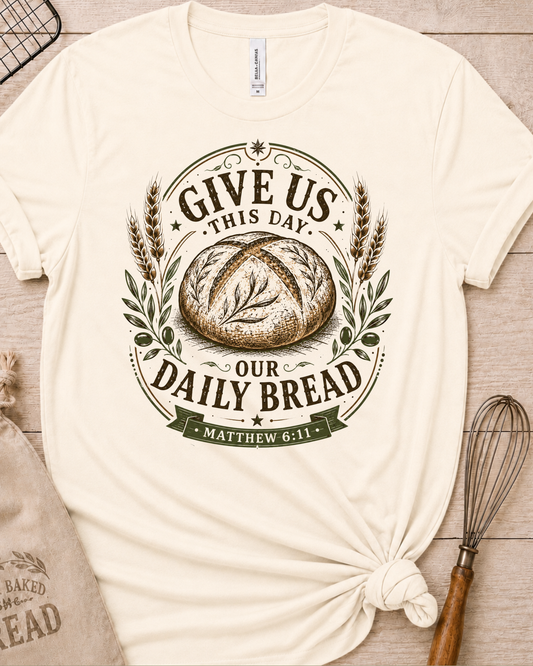 Natural cream women's relaxed fit t-shirt with the Daily Bread emblem, a clean badge-style bread illustration inspired by Matthew 6:11.