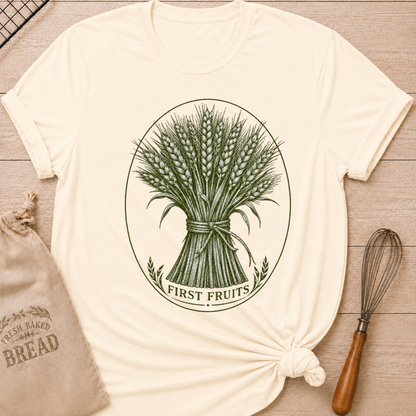 Natural women's relaxed fit tee with a detailed bundle of wheat tied by hand and framed in a classic vintage oval, with First Fruits lettering