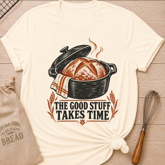 Natural women's relaxed fit tee with a warm artisan loaf rising from a classic Dutch oven with wheat accents and vintage distressed Good Stuff Takes Time lettering