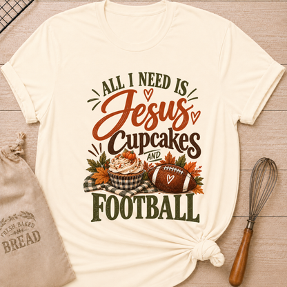 Natural women's relaxed fit tee with bold vintage All I Need Is Jesus, Cupcakes and Football lettering, a pumpkin topped cupcake, autumn leaves and a football on a gingham blanket
