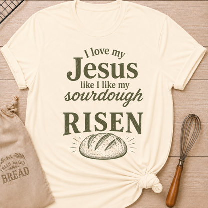 Natural women's relaxed fit t-shirt with the words I Love My Jesus Like I Like My Sourdough, Risen in bold vintage lettering and a rustic loaf of bread.