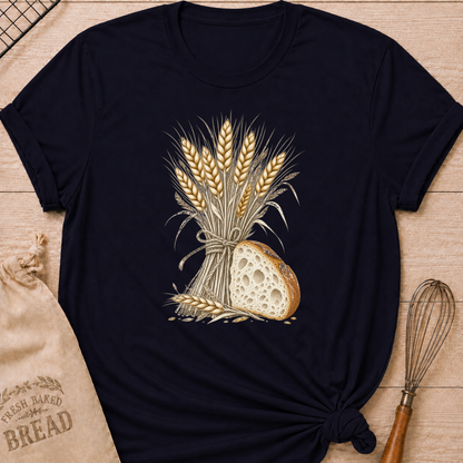 Navy women's relaxed fit tee with a hand-tied bundle of golden wheat beside a richly textured slice of artisan bread