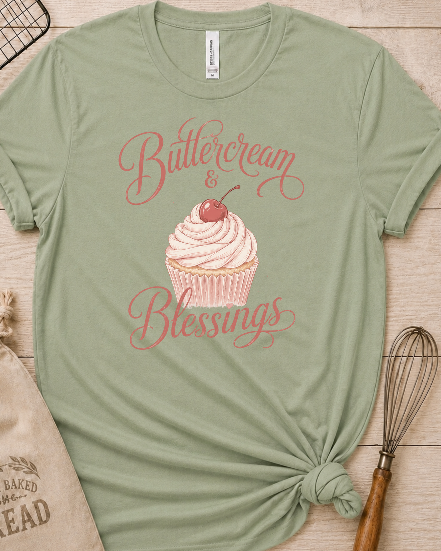 Sage green women's relaxed fit t-shirt reading Buttercream and Blessings with a frosted cupcake illustration.